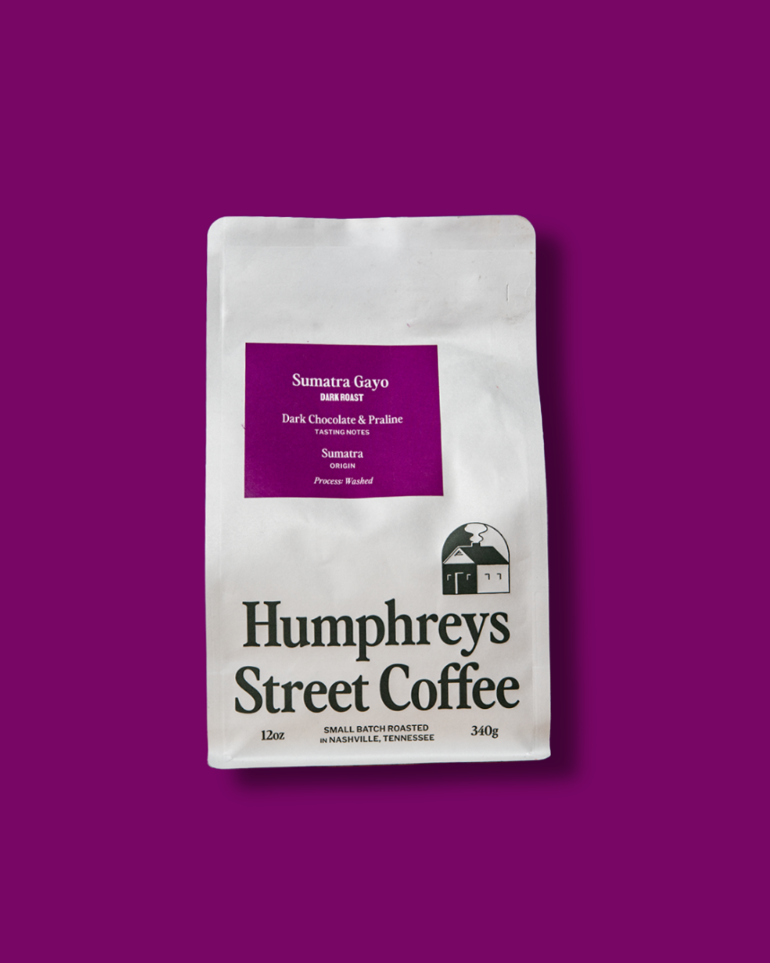 A 12 oz bag of Humphreys Street Coffee, Sumatra Gayo, displayed on a solid deep purple background.