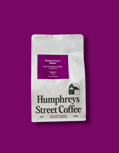 A 12 oz bag of Humphreys Street Coffee, Sumatra Gayo, displayed on a solid deep purple background.